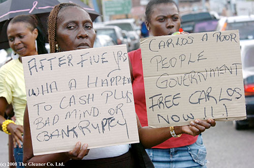 Pro-Cash Plus supporters bearing placards outside Half Way Tree Courthouse reveal greater trust and confidence in Cash Plus CEO Carlos Hill, than Government! © 2008 The Gleaner